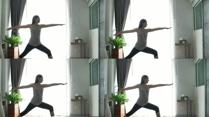 年轻的亚洲孕妇在客厅锻炼