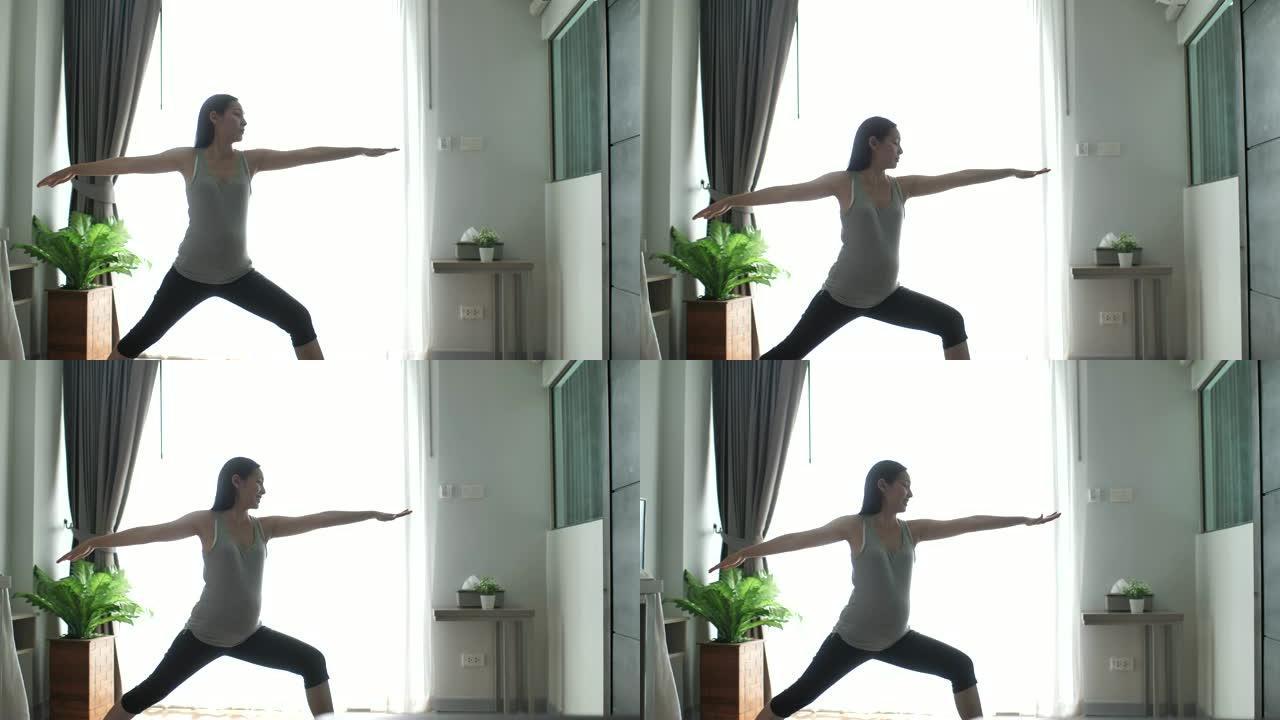 年轻的亚洲孕妇在客厅锻炼