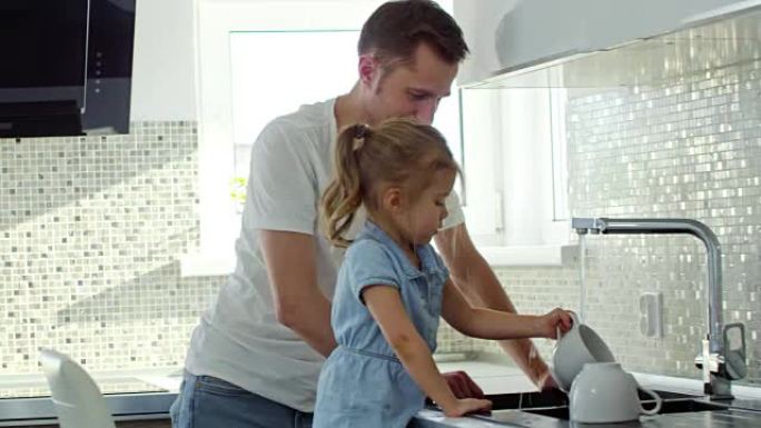 开朗的爸爸和小女孩洗碗