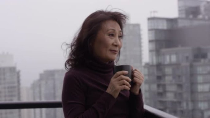 美丽的高级女人在摩天大楼里喝咖啡