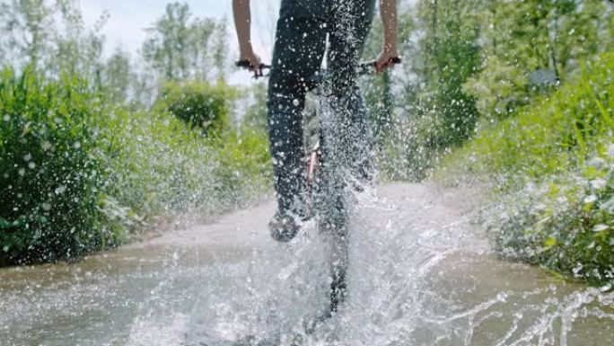 SLO MO Mountain骑自行车的人在水坑中泼水