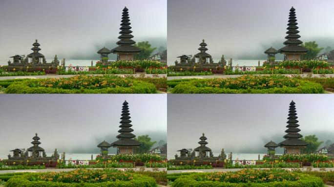 印度尼西亚巴厘岛。Pura Ulun Danu Bratan寺被美丽的花朵包围，背景为薄雾覆盖的水。