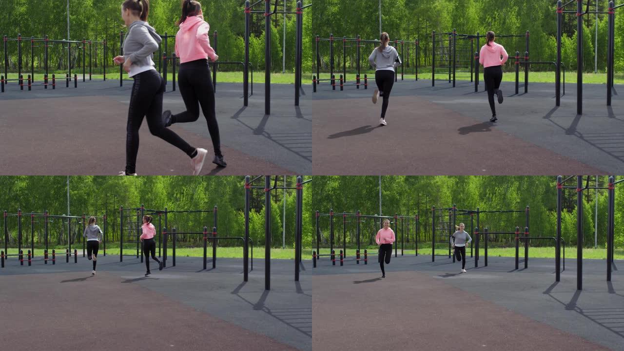运动型双胞胎姐妹在户外健身房慢跑