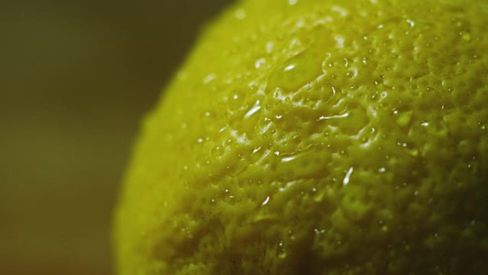 关闭或微距一片柠檬，一滴水以慢动作落下。水果散发出新鲜感和果汁馅。
