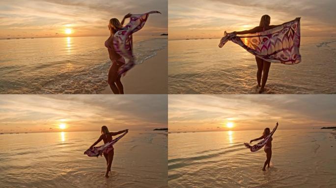 SLO MO欣喜若狂的女人在热带海滩上旋转时拿着纱笼
