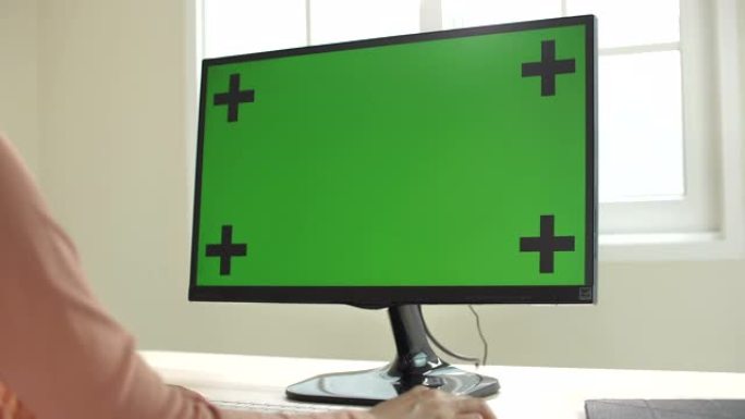 女人在家中使用带有绿屏的计算机，多莉开枪
