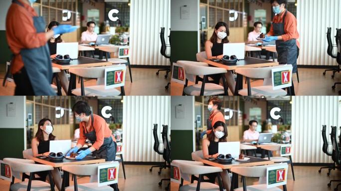 一位亚洲华人小型企业咖啡馆老板在餐桌旁为顾客提供甜点，同时练习社交距离sop标准操作程序作为新常态