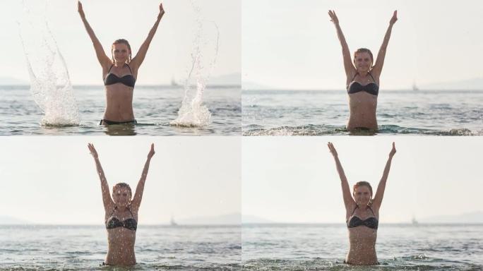 年轻女子站在海中向空中喷洒海水