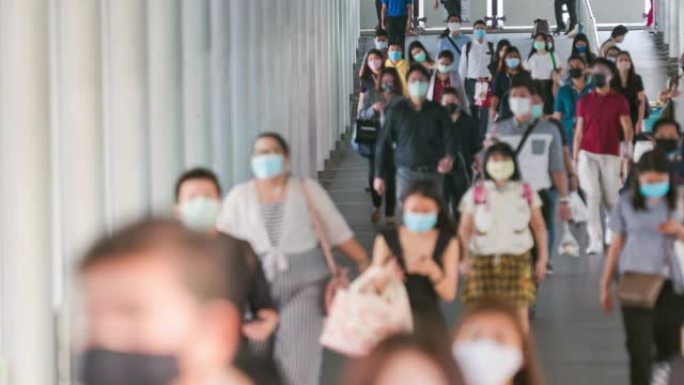 时间流逝模糊背景人群亚洲人在早上高峰时间去曼谷工作场所时，穿着面部保护装置预防冠状病毒或新型冠状病毒