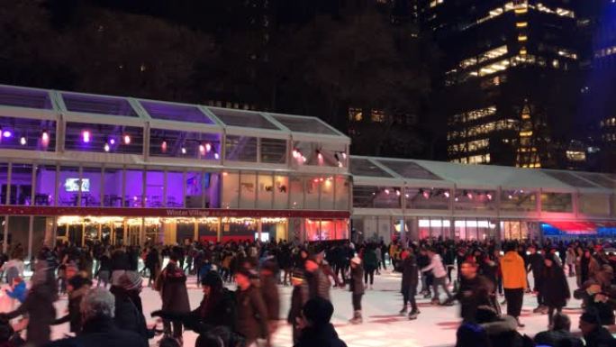 在美国纽约市曼哈顿布莱恩特公园冬季村滑冰的人群。