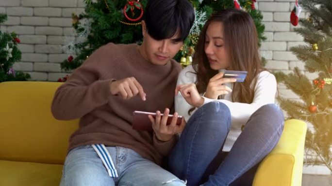 年轻的亚洲夫妇庆祝圣诞节假期并进行在线购物