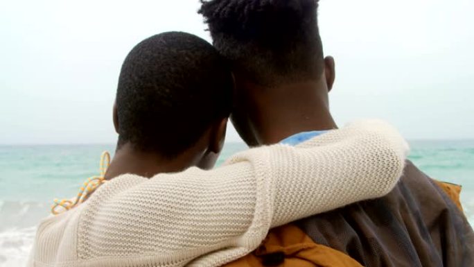 非裔美国夫妇在海滩上互相拥抱的后视图4k