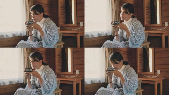 亚洲旅游妇女在日本的小屋喝热茶