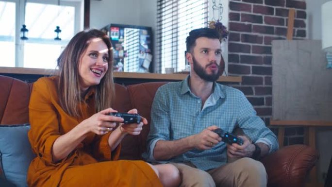 年轻开朗的白人丈夫和妻子在家里玩电子游戏，享受休闲时间的慢动作。