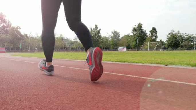 慢动作: 女跑步者在跑道上跑步，腿部特写