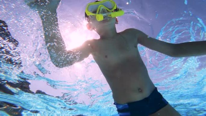 一个男孩戴着潜水面具游泳，在水下被枪杀