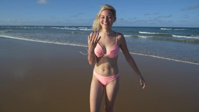 南非，一个美丽的年轻女子调情地呼唤某人进入海浪寻找乐趣的4k慢动作视图