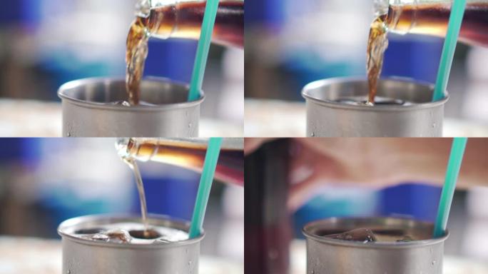 将可乐水倒入餐厅的一杯冰中的特写镜头，慢动作