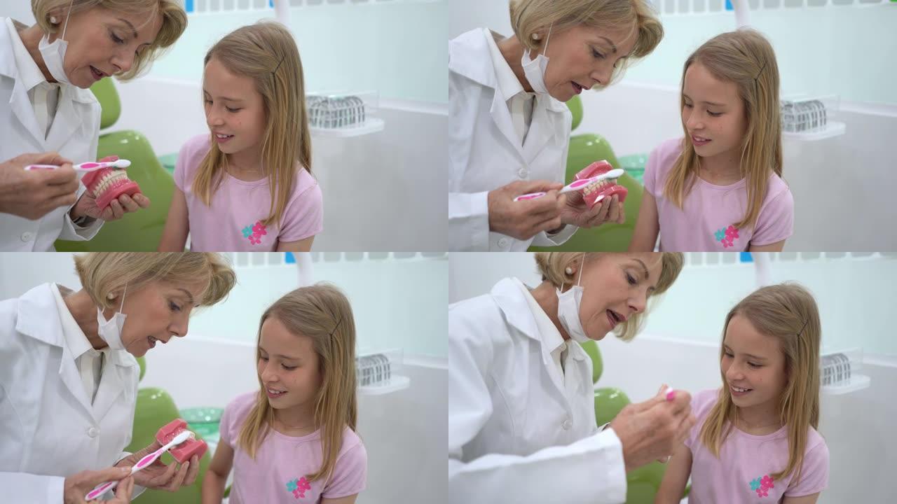 女牙医向小女孩解释如何在咨询期间正确刷牙