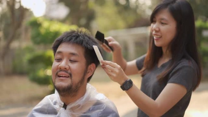 亚洲检疫夫妇在新型冠状病毒肺炎电晕病毒情况下在家用剪刀剪头发