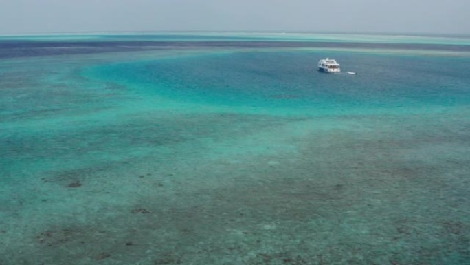 拥有白色沙滩，清澈的海水和近海游艇的荒岛风景的鸟瞰图