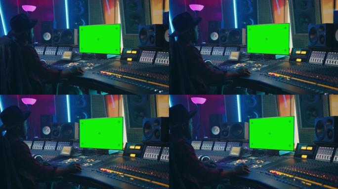 在音乐唱片工作室工作的时尚音频工程师/制作人，使用绿屏色度键计算机显示器、混音器板均衡器和控制台来创