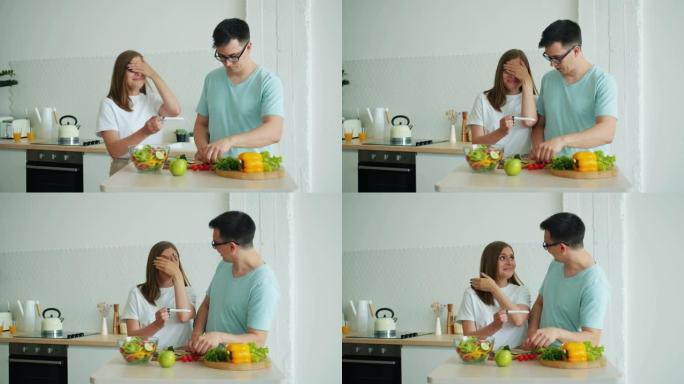 男人丈夫在厨房做饭时快乐的女孩带怀孕测试