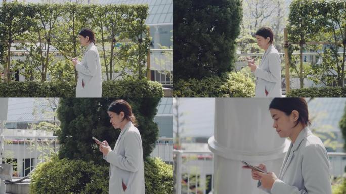 女商人在东京市散步时使用和键入短信。