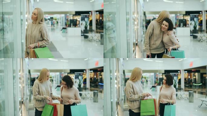快乐的年轻女性朋友在购物中心开会，讨论购买商品，并在纸袋中查看商品，然后一起购物。友谊和购物狂的概念