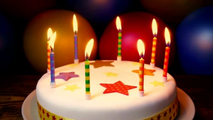 生日蛋糕上的蜡烛与五颜六色的气球