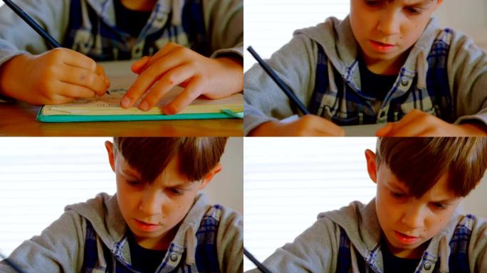 高加索男孩在舒适的家庭4k餐桌上做作业的前视图