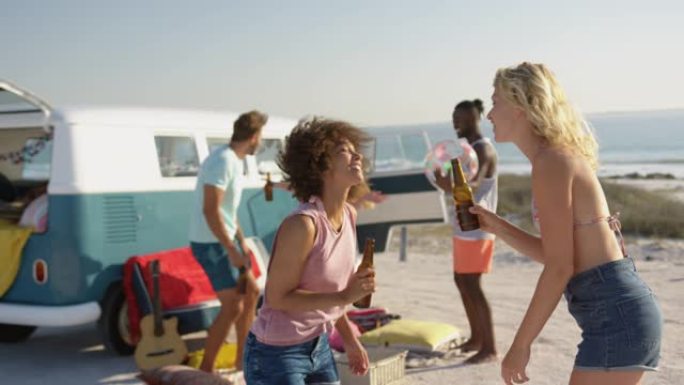 年轻的成年朋友站在4k海滩上的露营车旁