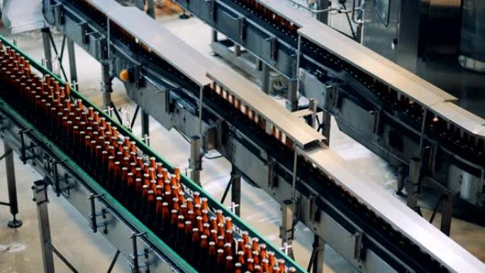 用瓶子工作的啤酒厂输送机。工厂设施内部。