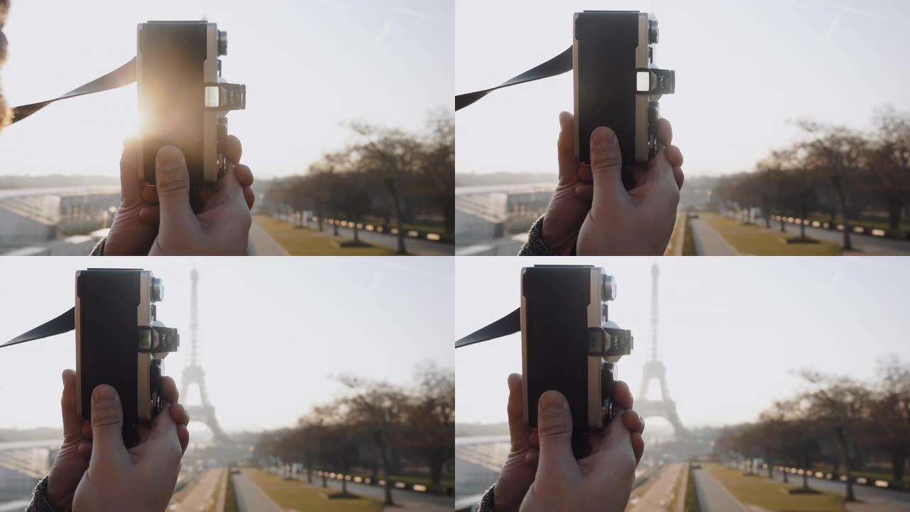 特写摄影师用老式电影相机慢动作拍摄背光日落巴黎埃菲尔铁塔的照片。