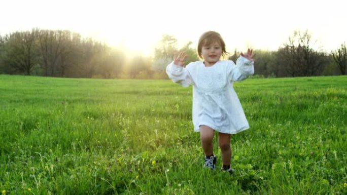 两岁的女孩奔向草地上的一棵树，并随着他的奔跑而成长。成长的概念，生命的流逝，时间的流逝。愉快的生活和