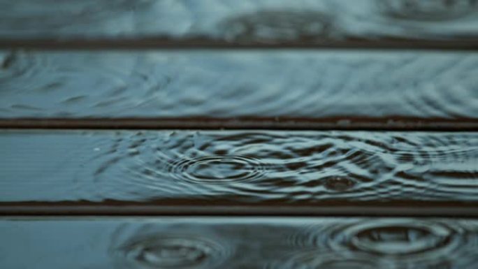 宏观: 雨滴落在潮湿的木地板上，在水中产生涟漪