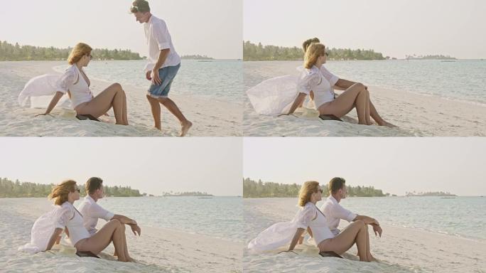 女士夫妇在马尔代夫阳光明媚的热带白色沙滩上放松