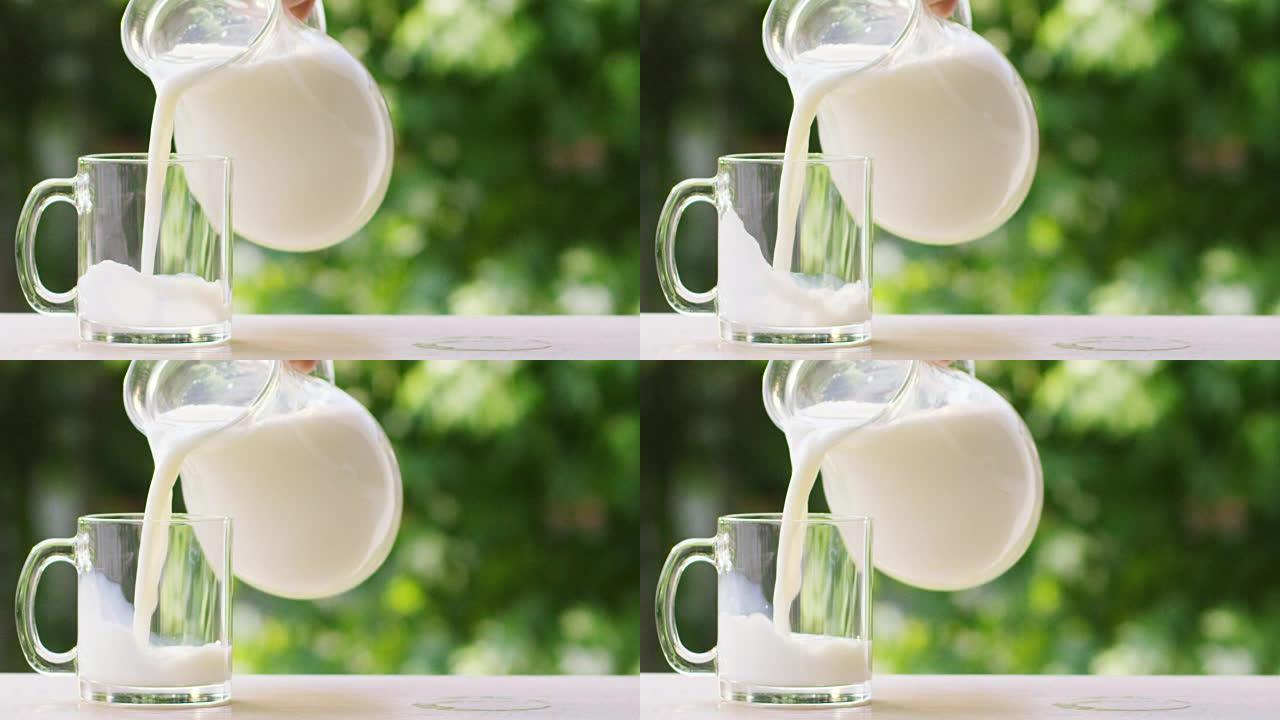 在花园里一个阳光明媚的日子里，男孩的手将牛奶倒入一个透明的杯子中，牛奶以慢动作落下。