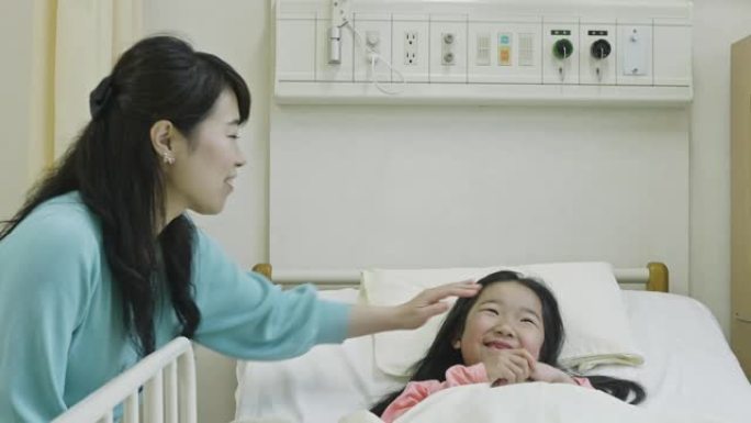日本母亲在医院病床上照顾生病的女儿