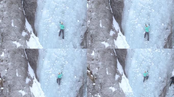 无人机，复制空间: 无畏的女人爬上华丽的冰冻瀑布。