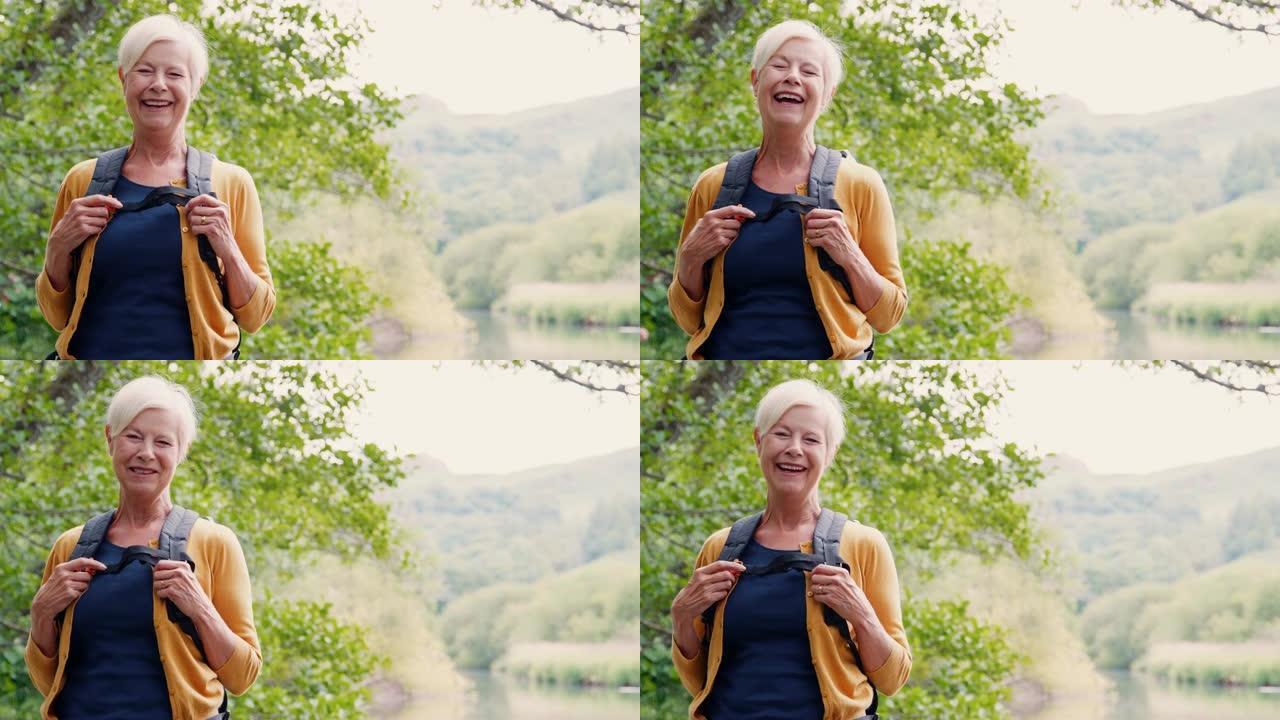 英国湖区沿河徒步旅行的笑女老人的慢动作肖像