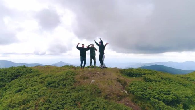 快乐的四个人在山顶上跳舞，风景优美