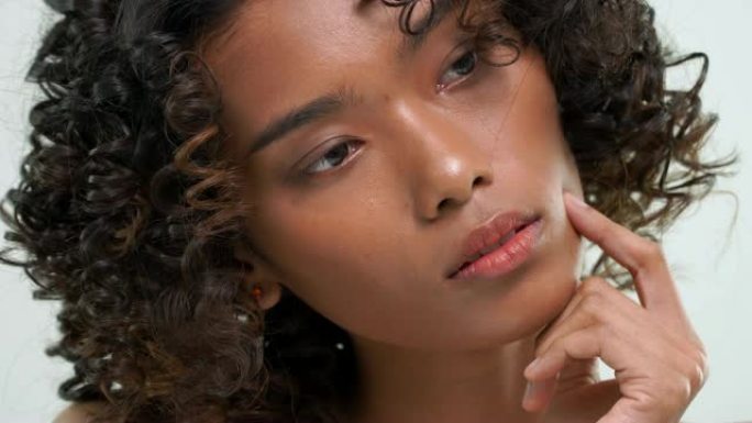 非洲妇女用美容护肤产品在白色背景上摩擦皮肤。