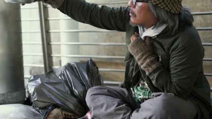 向上倾斜: 无家可归者在人行道上拿着乞讨碗。