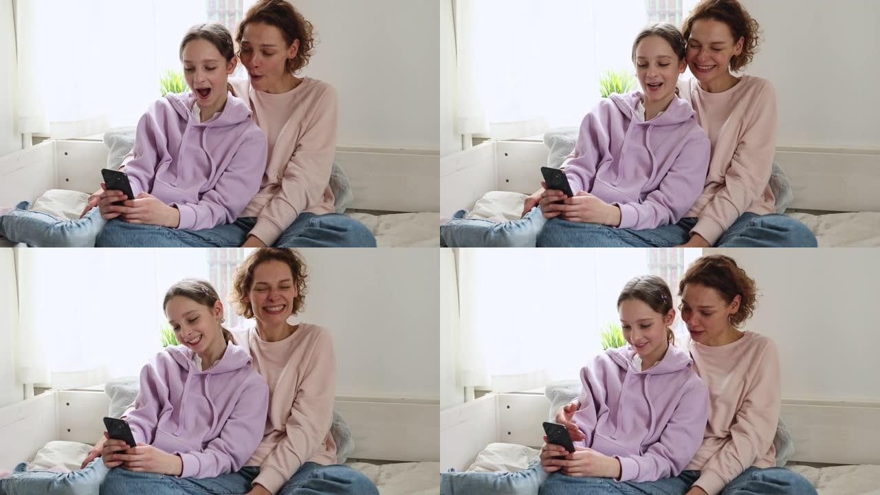 快乐的十几岁的女儿用智能手机和妈妈玩得开心