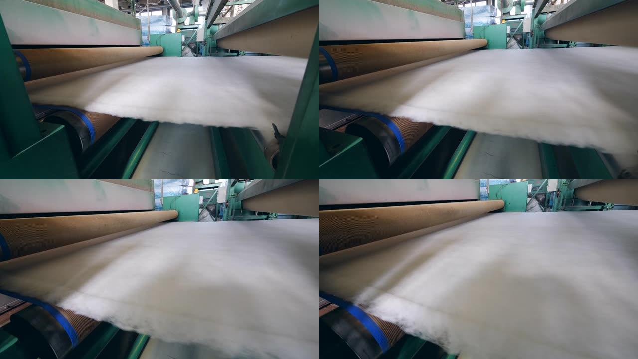 工厂滚筒在房间里工作时移动白色棉絮。