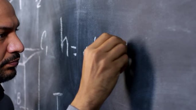 在黑板上写数学公式的男教授