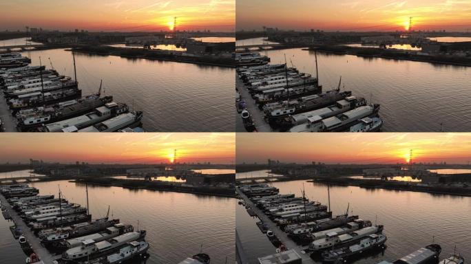 空中电影无人机可以看到舒适的城市港口，远处停着船只和城市。日落时美丽的城市海滨景观。顶视图。