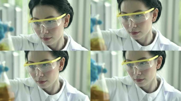 亚洲女化学家倒黄色物质试管