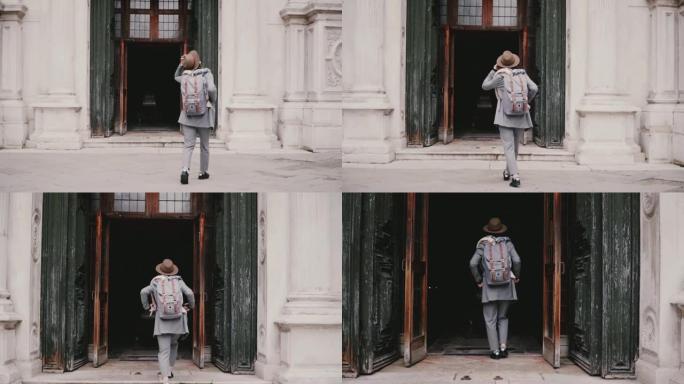 镜头跟随年轻时尚的女游客走进意大利威尼斯的黑暗古建筑门慢动作。